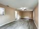 Bright living area featuring gray wood-look floors, ceiling fan, and openings to adjoining rooms for an open flow at 320 S Elm Rd, Lakeland, FL 33801