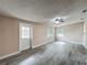 Spacious living room with modern gray vinyl plank floors, a ceiling fan, and multiple windows offering natural light at 320 S Elm Rd, Lakeland, FL 33801