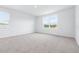 Bright, carpeted bedroom with two windows, white walls, and natural light at 3265 Vesara Dr, Davenport, FL 33837