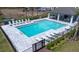 Aerial view of a community pool and cabana, complete with lounge chairs and palm trees at 3265 Vesara Dr, Davenport, FL 33837