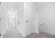 Bright hallway with carpeted floors and white walls leading to bedrooms, and stairs with handrail on the right at 3265 Vesara Dr, Davenport, FL 33837