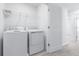 Laundry room featuring a white washer and dryer, wire shelving, white walls, and carpeted flooring at 3265 Vesara Dr, Davenport, FL 33837