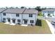 Aerial perspective of townhomes showcasing the rear exterior with patios and a lawn at 3265 Vesara Dr, Davenport, FL 33837