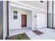 Inviting entryway with brown door, neutral siding, and manicured landscaping at 3269 Vesara, Davenport, FL 33837