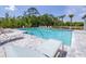 A swimming pool with chairs, a fence, and lush landscaping at 3269 Vesara, Davenport, FL 33837