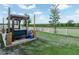 Inviting backyard featuring a wooden pergola, lush green grass, and a classic white picket fence at 3862 Whitney Way, Haines City, FL 33844