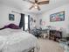 Bedroom with a unique bed frame, black out curtains, a ceiling fan, desk, and playful wall art at 3862 Whitney Way, Haines City, FL 33844