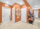 Inviting hallway featuring neutral tile flooring, closet space, and a charming vintage sewing machine console table at 3862 Whitney Way, Haines City, FL 33844