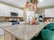 Spacious kitchen with granite island, stainless steel appliances, white cabinets, and a hanging pot rack at 3862 Whitney Way, Haines City, FL 33844
