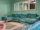 Cozy living room with a plush sectional sofa and stylish decorative mirrors on green walls at 3862 Whitney Way, Haines City, FL 33844