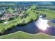 Expansive aerial view of a golf course community with serene lake and beautiful homes at 409 Greenfield Rd, Winter Haven, FL 33884