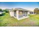 Exterior showing the home's screened in lanai and well-maintained lawn and landscaping at 409 Greenfield Rd, Winter Haven, FL 33884