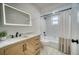 Renovated bathroom featuring a modern vanity, and shower/tub combo with white tile at 409 Greenfield Rd, Winter Haven, FL 33884