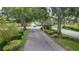 Entrance to community featuring mature trees, landscaping, and a guard house at 409 Greenfield Rd, Winter Haven, FL 33884