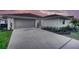 Charming single-story home with a gray two-car garage, white stucco, and a well-manicured lawn at 409 Greenfield Rd, Winter Haven, FL 33884
