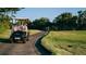 People enjoying a golf outing while driving a golf cart on a paved course at 409 Greenfield Rd, Winter Haven, FL 33884