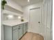 Hallway with built-in cabinets, quartz countertops, shelving with LED lighting, and a laundry closet at 409 Greenfield Rd, Winter Haven, FL 33884