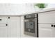 Close up of a stainless steel drawer style microwave with white cabinets, dark hardware and stone countertops at 409 Greenfield Rd, Winter Haven, FL 33884
