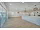Open living space with wood floors, bar seating, lots of natural light from the sliding glass doors and modern lighting at 409 Greenfield Rd, Winter Haven, FL 33884