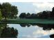 Picturesque pond reflecting the sky and surrounding landscape, offering a tranquil setting at 409 Greenfield Rd, Winter Haven, FL 33884