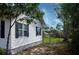 Side view of a charming home showing the fenced yard, exterior details, and nearby greenery at 420 N 5Th St, Lake Wales, FL 33853