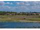 Picturesque view of homes in a golf community, with a pond and golf cart, surrounded by lush greenery at 4279 Ashton Club Dr, Lake Wales, FL 33859