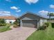 Attached two-car garage with brick paver driveway surrounded by lush landscaping and manicured lawn at 4279 Ashton Club Dr, Lake Wales, FL 33859
