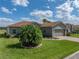 Charming single-story home with a well-maintained lawn, a brick driveway, and a mature palm tree at 4279 Ashton Club Dr, Lake Wales, FL 33859