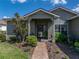 Inviting front porch with brick walkway, lush landscaping, and charming details at 4279 Ashton Club Dr, Lake Wales, FL 33859