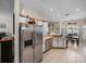 Open kitchen showcasing stainless steel refrigerator and connection to breakfast nook and dining area at 4279 Ashton Club Dr, Lake Wales, FL 33859