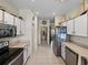 Functional kitchen design with white cabinets, tile floors and stainless steel refrigerator at 4279 Ashton Club Dr, Lake Wales, FL 33859