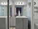 Compact bathroom featuring a gray vanity, decorative mirror, wall-mounted phone, toilet, and bathtub with shower at 43420 Highway 27 # 445, Davenport, FL 33837