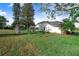 Spacious fenced in backyard with an in-ground screened pool, large green lawn, and mature trees at 508 Starr Ridge Dr, Lake Wales, FL 33898