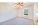 Carpeted bedroom featuring a ceiling fan and a window overlooking the exterior landscape at 508 Starr Ridge Dr, Lake Wales, FL 33898