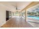 Spacious covered brick patio featuring ceiling fans and a view of the screened-in pool and lush backyard at 508 Starr Ridge Dr, Lake Wales, FL 33898