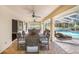 Spacious covered brick patio furnished with dining set and seating overlooking the screened-in pool and backyard at 508 Starr Ridge Dr, Lake Wales, FL 33898