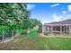 Screened pool is set in a large, grassy backyard, with lush trees and landscaping at 508 Starr Ridge Dr, Lake Wales, FL 33898
