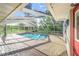 Screened-in pool with an open-air design and brick patio, surrounded by lush greenery and blue skies at 508 Starr Ridge Dr, Lake Wales, FL 33898
