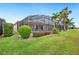 Spacious backyard with a screened-in lanai, palm trees, and well-maintained lawn at 5200 Pebble Beach Blvd, Winter Haven, FL 33884