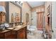 Cozy bathroom featuring elegant wood cabinets, decorative wallpaper, and a shower-tub combo at 5200 Pebble Beach Blvd, Winter Haven, FL 33884