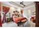 Beautiful bedroom featuring a tray ceiling, ornate draperies, and bench at 5200 Pebble Beach Blvd, Winter Haven, FL 33884