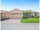 Charming single-story home with a well-manicured lawn, brick driveway, and attached two-car garage at 5200 Pebble Beach Blvd, Winter Haven, FL 33884