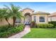 Close up of beautiful home exterior with manicured lawn, brick pathway, and a charming entry way at 5200 Pebble Beach Blvd, Winter Haven, FL 33884