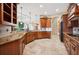 Spacious kitchen featuring custom wood cabinetry, granite countertops, and travertine flooring at 5200 Pebble Beach Blvd, Winter Haven, FL 33884