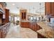 Spacious kitchen featuring custom wood cabinetry, granite countertops, and travertine flooring at 5200 Pebble Beach Blvd, Winter Haven, FL 33884