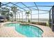 Screened pool and spa overlooking the water, surrounded by lush landscaping and ample lounge seating at 5200 Pebble Beach Blvd, Winter Haven, FL 33884