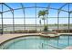 Inviting screened-in pool area with spa, offering stunning waterfront views for a peaceful retreat at 5200 Pebble Beach Blvd, Winter Haven, FL 33884
