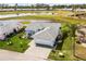Aerial view of a beautiful home with a manicured lawn, a lake view, and a golf course in the background at 530 Eastlake Dr, Haines City, FL 33844
