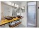 Modern bathroom with dual vessel sinks, wood counter, large mirror, and glass shower at 530 Eastlake Dr, Haines City, FL 33844