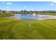 Scenic golf course view with a tranquil pond, fountain, and lush green fairways, perfect for outdoor enthusiasts at 530 Eastlake Dr, Haines City, FL 33844